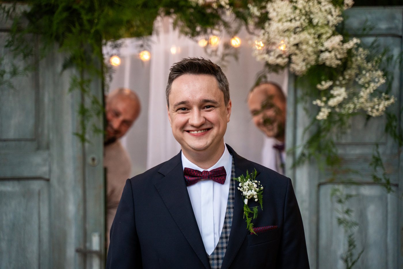 Uśmiechnięty pan młody w drzwiach — ślub Magda i Bernard