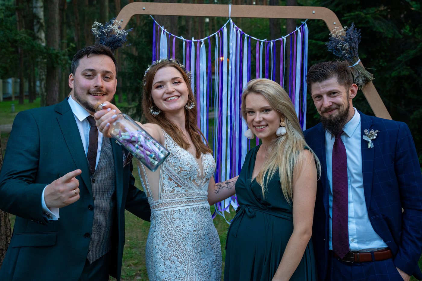 Zdjęcie grupowe przy ściance boho w lesie — ślub Marta i Patryk